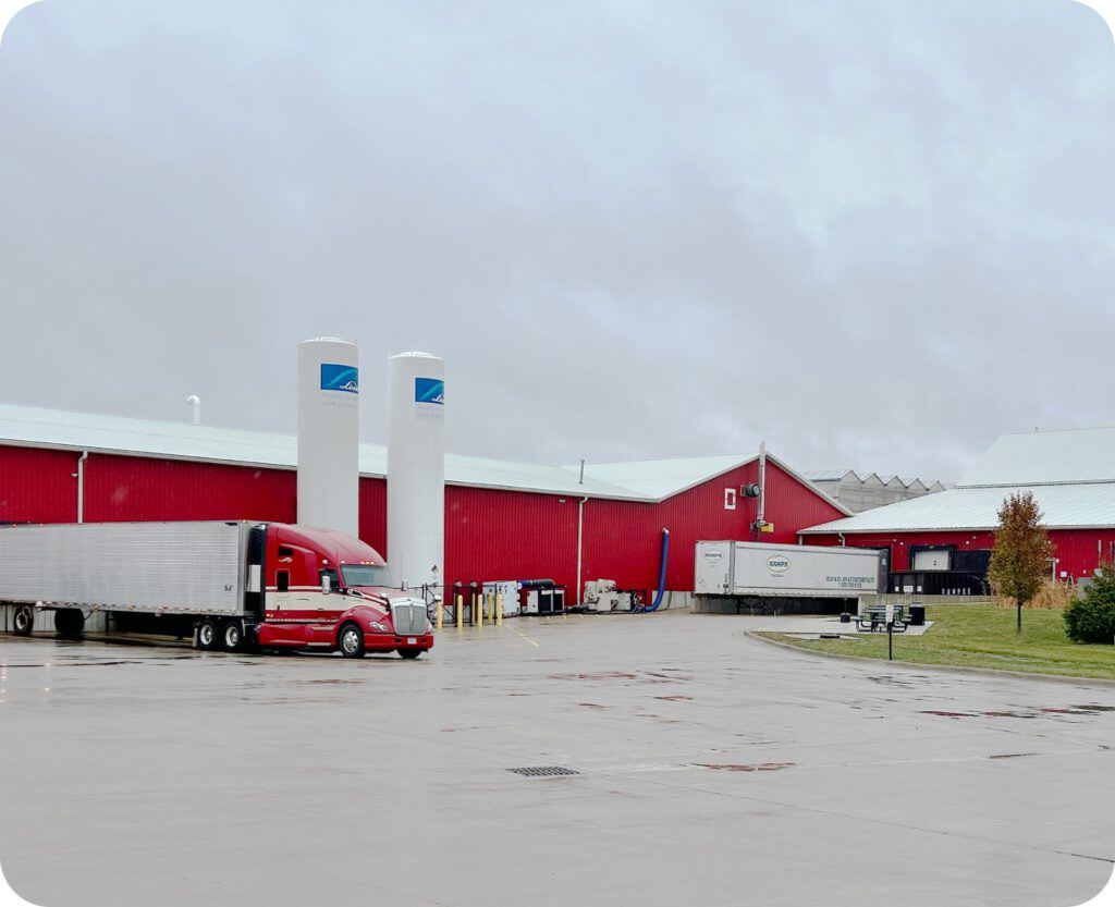 Old Souls Farms red warehouse facility exterior with refrigerated transport trucks and storage tanks in Saint Paris, Ohio